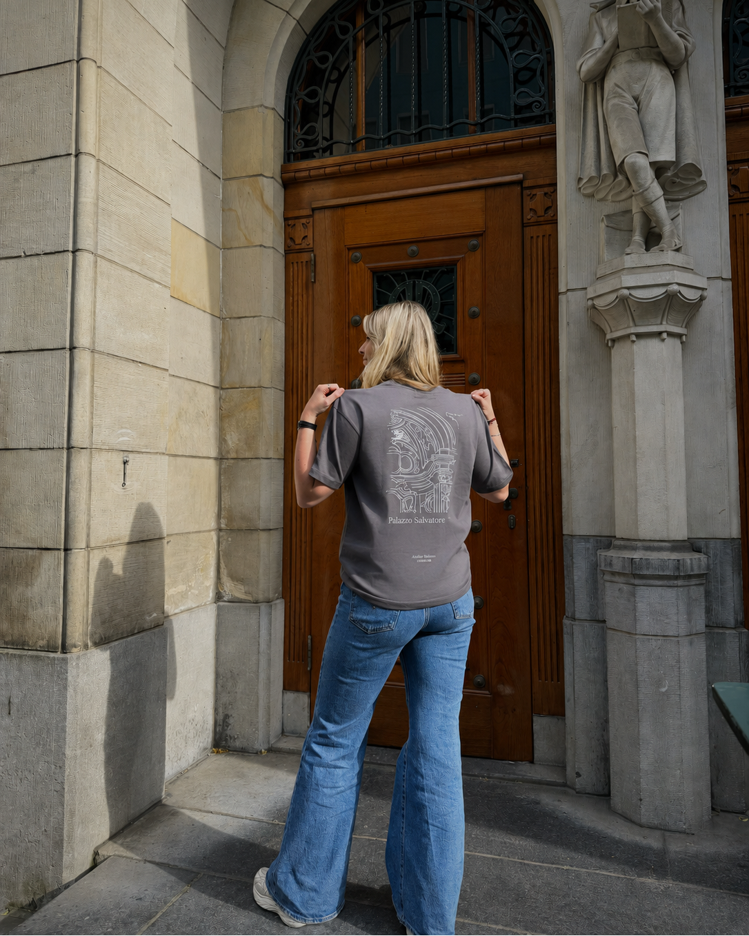 Person taking a photo of a wooden door with stone architecture