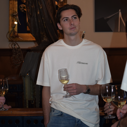 Man in a restaurant setting wearing the Fortissimo Colosseo t-shirt in Creme 