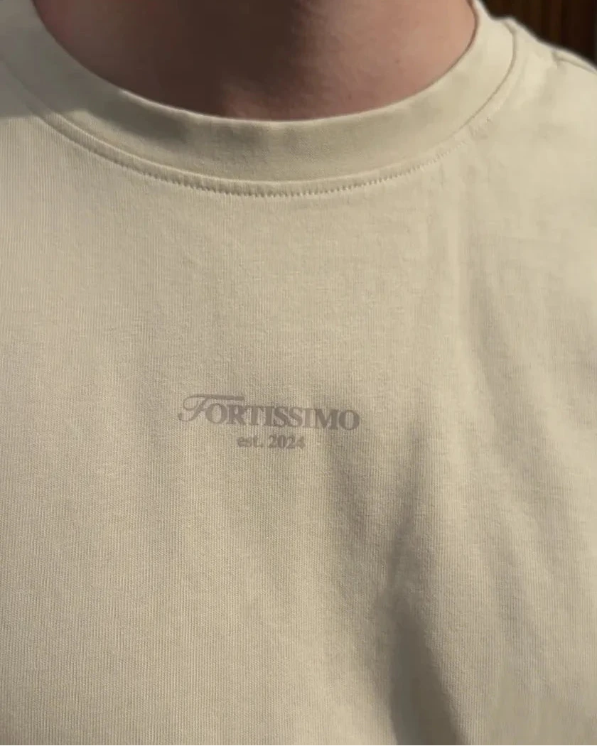 Beige t-shirt with 'FORTISSIMO est. 2024' logo on a plain background