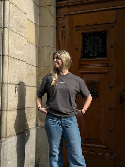 Woman standing in front of a large wooden door on a stone building